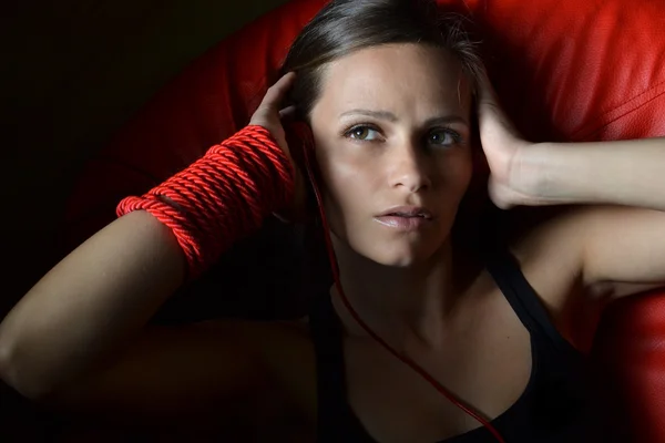 Een mooie jonge vrouw met de rode hoofdtelefoon — Stockfoto