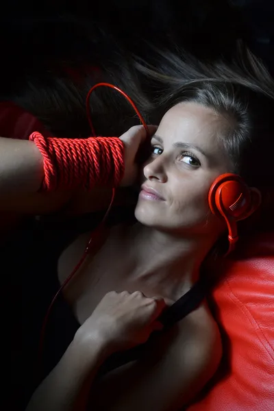 Una hermosa joven con los auriculares rojos —  Fotos de Stock