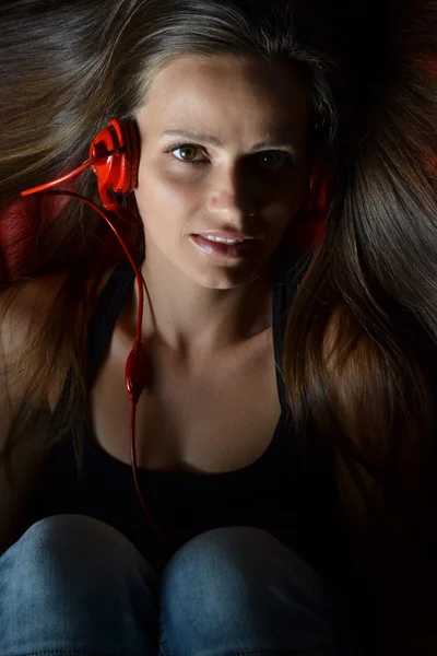 Una hermosa joven con los auriculares rojos —  Fotos de Stock