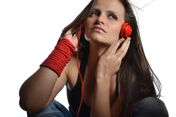 Μια όμορφη νεαρή γυναίκα με το κόκκινο ακουστικά — Φωτογραφία Αρχείου