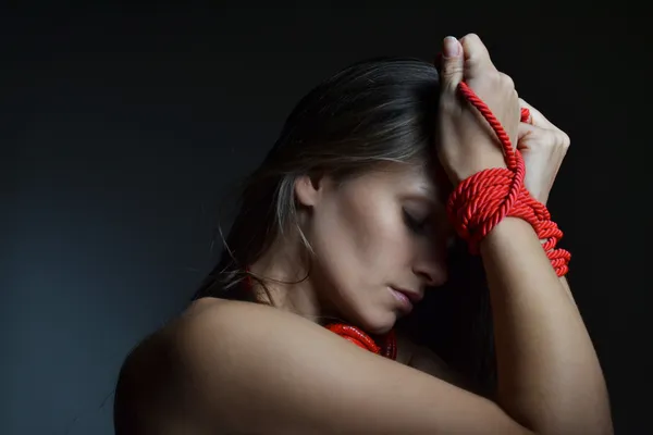 Schöne junge Frau mit dem roten Seil gebunden — Stockfoto