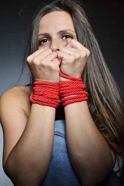 Beautiful young woman tied with the red rope — Stock Photo, Image