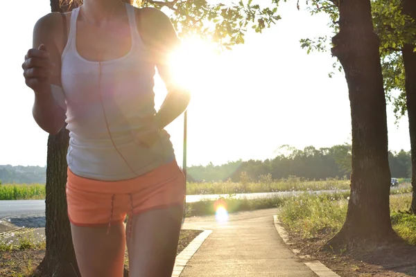 Young woman running in the park at sunset or sunrise — Stock Photo, Image