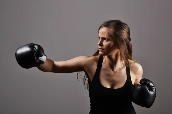 Mulher fitness bonita com as luvas de boxe preto — Fotografia de Stock