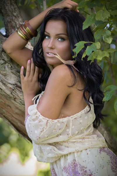 Mujer posando en el vestido beige cerca del árbol —  Fotos de Stock