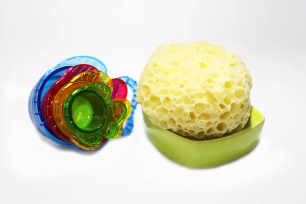プラスチック製のおもちゃを持つ黄色の風呂洗浄スポンジ — ストック写真