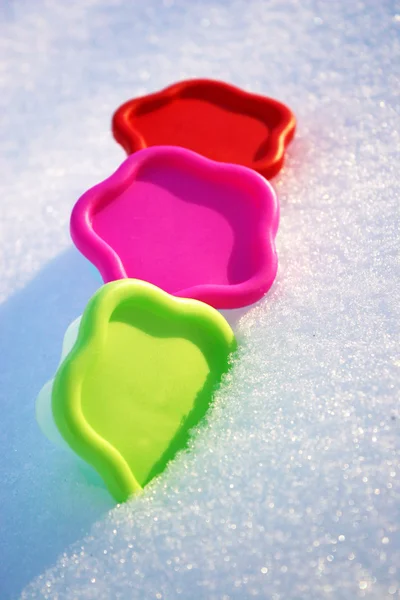 Colored molds green red and pink in the snow in a winter day — Stock Photo, Image