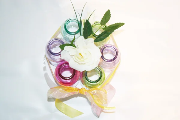 Barevná skleněná láhev s růžovou mašlí — Stock fotografie