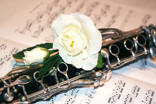 Close up of clarinet on a score with wite rose Stock Photo