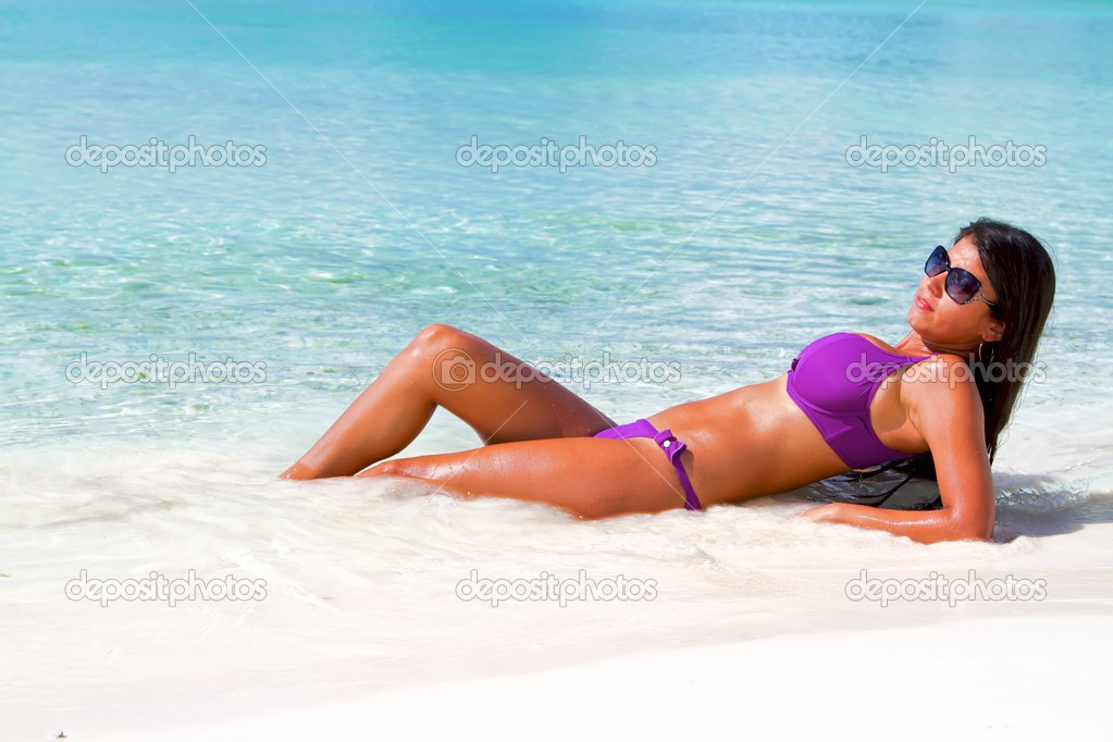 The beautiful sexy young girl in bikini on a beach