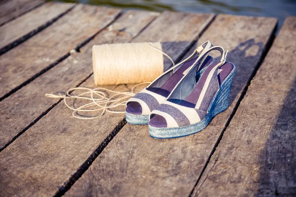 Une boule de fil autour des femmes sandales, chaussures à l'extérieur — Photo