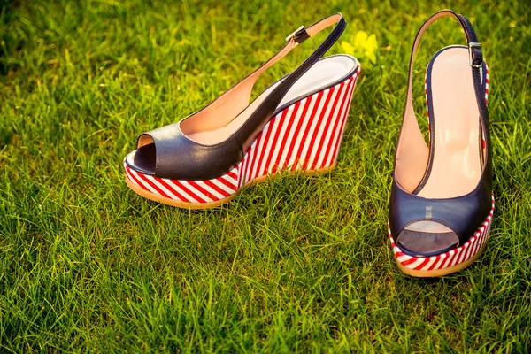 Stylové sandály, ležet na trávě v zahradě — Stock fotografie