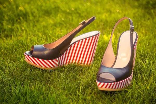 Sandalias con estilo, se encuentran en la hierba en el jardín — Foto de Stock