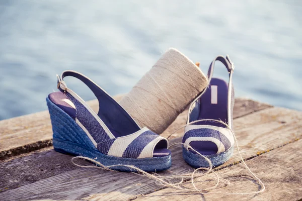 Proužkované sandály, leží na prsou jezero, Klubíčko, dámská obuv — Stock fotografie