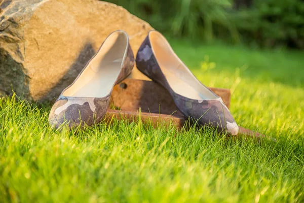 Military ballet flats lie on the grass in the garden — Stock Photo, Image