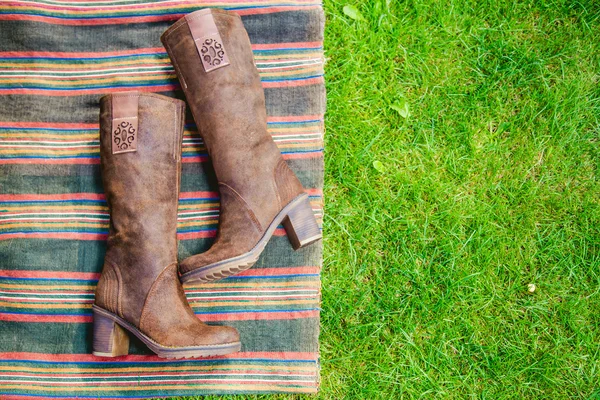 Botas de gamuza mujeres yacen en la hierba — Foto de Stock