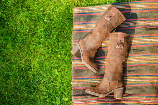 Botas de gamuza mujeres yacen en la hierba — Foto de Stock