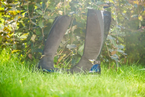 Bottes en daim noir dans le jardin d'automne, chaussures pour femmes — Photo