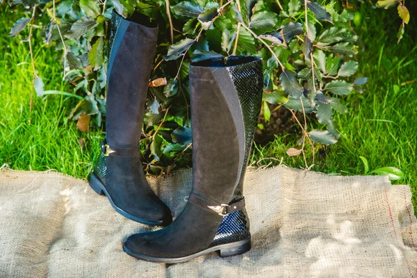 Suède laarzen vrouwen liggen op het gras — Stockfoto