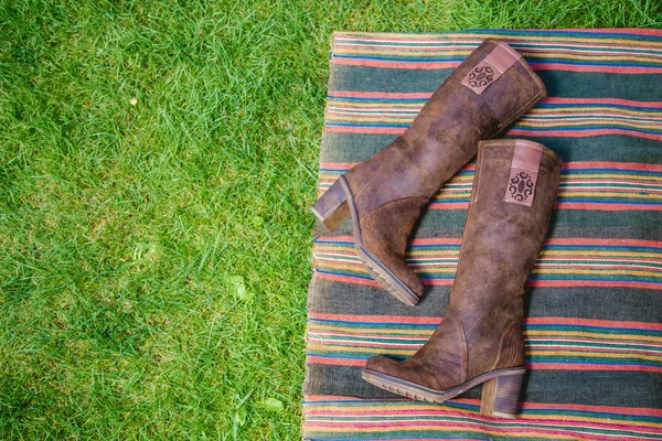 Botas de gamuza mujeres yacen en la hierba — Foto de Stock