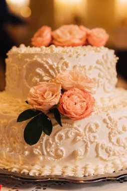 Gül tomurcuklarıyla süslenmiş beyaz kremalı pasta..