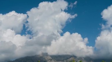 Timelapse of beautifTime lapse of beautifully swirling clouds over a mountain peak.ully swirling clouds over a mountain peak. High quality 4k footage