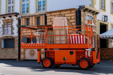 Elektrikli mobil hava çalışma platformu. Profesyonel ressamlar kaldırıma park etmiş makas kaldıracı.