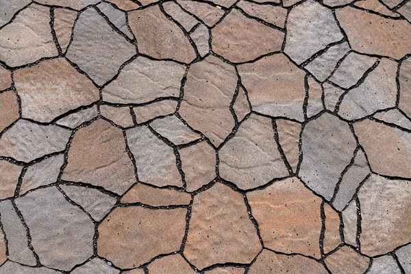 Road tiles laid out in the form of dry cracked earth. Close up.