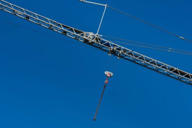 Mavi gökyüzüne bir kancayla vinç patladı. Kancaya asılı metal bir zincir.