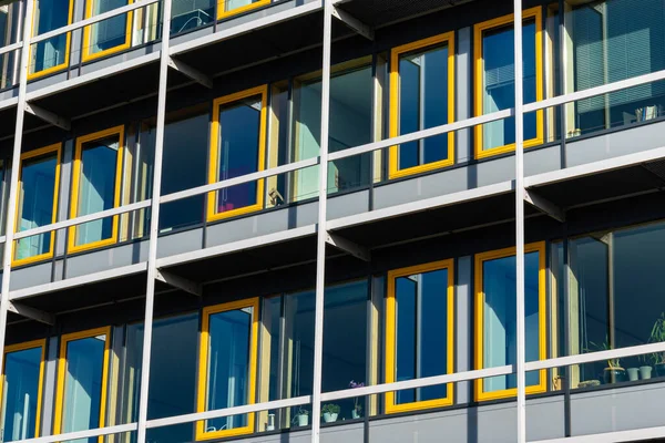 Fragment of the facade of the building with rectangular yellow windows.