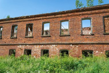 Terk edilmiş eski bir binanın tuğla duvarındaki pencereler.