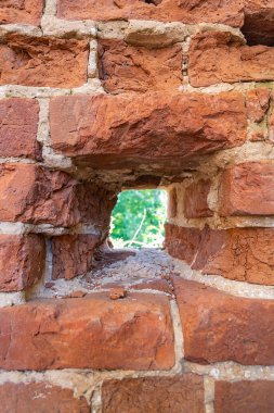 Eski kalenin tuğla duvarında küçük bir pencere açığı.
