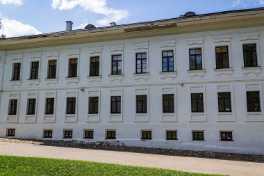 the wall of a stone three-storey building with many windows