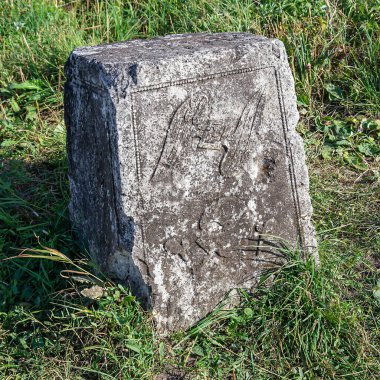 an ancient stone tombstone with an image erased from time