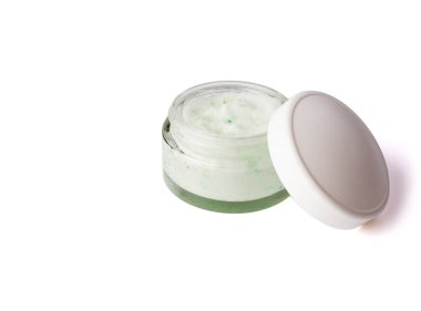 Yüz ve vücut için beyaz kapaklı cam bir kavanozda makyaj fırçası. Yeşil kristalli vücut fırçası. Beyaz arka planda izole edilmiş. Üst görünüm