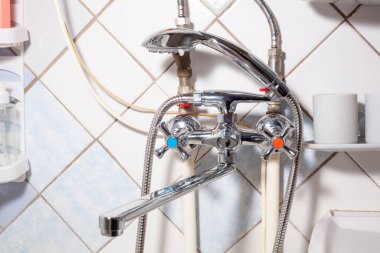 Banyoda krom musluk karıştırıcı musluğu var. Basit tesisat ekipmanları. Parlak karıştırıcı musluğu.