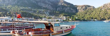 Turunc adlı küçük bir turistik köyde dağlarla ve kayalarla çevrili bir sahil. Panoramik manzara. Çamurlu zevk yatıyla manzara.