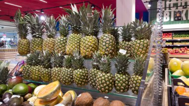 Bir sürü ananas meyvesi. Süpermarkette ananaslar tezgahta. Toptan ve egzotik meyve ticareti.