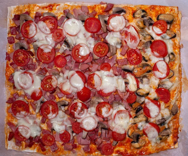 빵 판위에서 햄, 버섯, 모차렐라 치즈, 체리 토마토와 함께 피자를 먹습니다. 이탈리아 음식. 피자 위에 올려 놓은 풍경 — 스톡 사진
