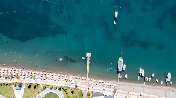Vista aérea de una playa llena de gente con sombrillas, gente nadando en el mar, día soleado. Drone vista de la playa con arena blanca — Foto de Stock