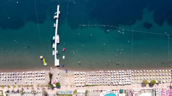 Vista aérea de una playa llena de gente con sombrillas, gente nadando en el mar, día soleado. Drone vista de la playa con arena blanca — Foto de Stock