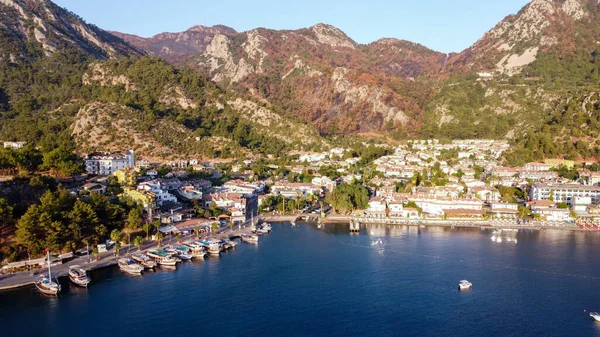 Deniz manzaralı drone. Turunc adlı küçük bir turistik köyde dağlarla ve kayalarla çevrili bir sahil. Çamurlu zevk yatıyla manzara.