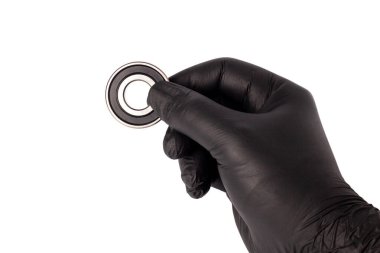 Metal rulo tutan nitril eldivenli bir erkek. Bilye yalıtılmış. Yüksek performanslı makinelerde kullanılan Süper Hassas Top Taşıyıcıları.