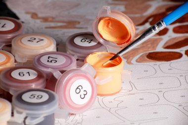 Kavanozu akrilik boya ve boya fırçasıyla açın. Sayılarla boyamak. Ev hobisindeki numaradan boyama. Kapatın. Kavanoz kapağına odaklan