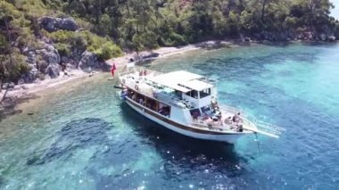 Kum kıyısı ve turkuaz su ile adanın yakınındaki mavi denizdeki yatın havadan görüntüsü. Türkiye 'de turistik tekne gezisi. Türkiye - 9 Eylül 2021