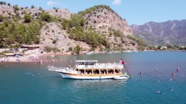 Marmaris 'teki Kizkumu Sahili' nin havadan görüntüsü. Ada koyunda kumsallı bir yat. İnsanları yüzdürmek. Gemiden suya atlamak. Türkiye 'de turistik tekne gezisi. Türkiye - 9 Eylül 2021