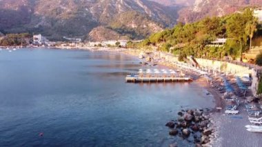 Türkiye 'nin Turunc kentindeki bir plajın havadan çekilmiş videosu. İHA 'larla, tatil köyü üzerinde gün doğumu görüntüleri. Şemsiyeler ve güneş yatağı kumsalda
