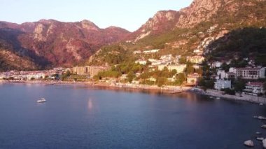 Türkiye 'nin Turunc kentindeki bir plajın havadan çekilmiş videosu. İHA 'larla, tatil köyü üzerinde gün doğumu görüntüleri. Şemsiyeler ve güneş yatağı kumsalda.