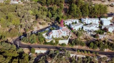 Çarpık dağ yolunun hava görüntüleri. Gün doğumunda virajlı yolda giden arabalar. Uzak dağ köyünden yılanlı yol