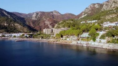 Türkiye 'nin Turunc tatil köyündeki sahil ve sahil manzaralı panoramik insansız hava aracı. Deniz manzaralı bir tatil köyü. Dağlarla çevrili bir tatil köyü.